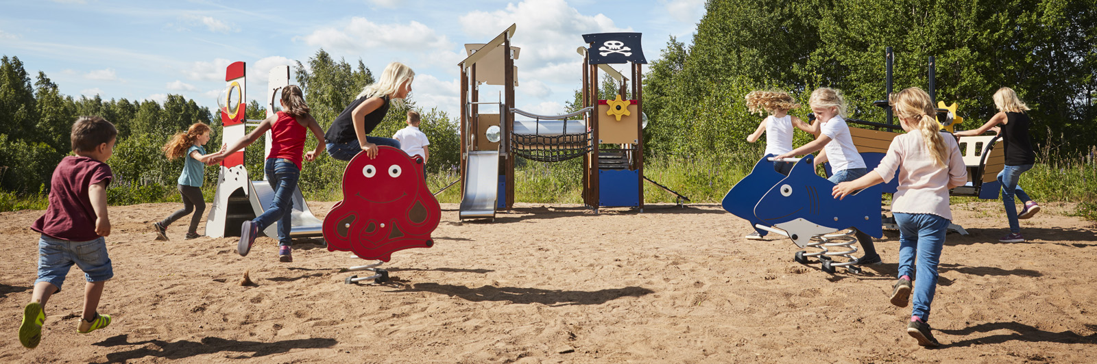 a group of children run towards a playground, splitting in different directions to reach their favourite equipment